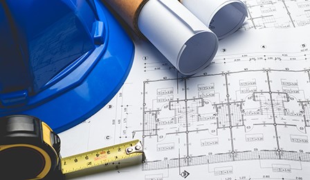 Construction hat on top of blue prints
